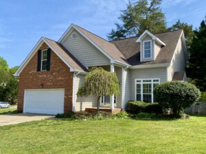 A house with a garage and trees in front of it