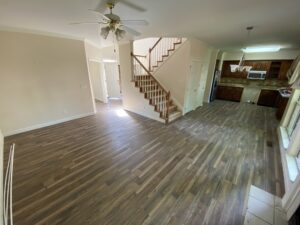 A living room with hard wood floors and stairs.