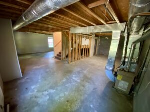 A room with exposed rafters and concrete floors.