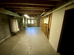 A view of the inside of a basement with exposed rafters.