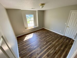 A room with hard wood floors and a window.