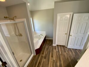 A bathroom with a shower, toilet and tub.