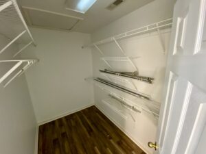 A closet with many shelves and clothes hanging on them.