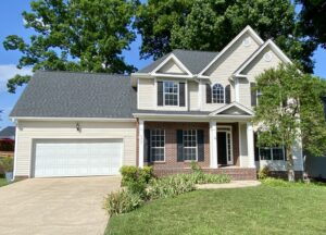 A house with a driveway and garage in front of it.