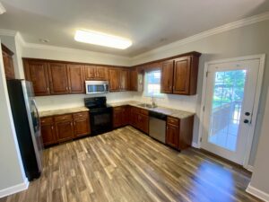 A kitchen with wooden cabinets and floors