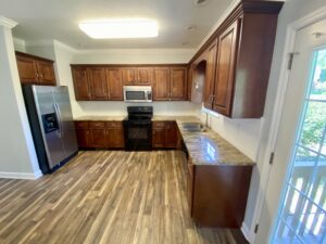 A kitchen with wooden floors and cabinets