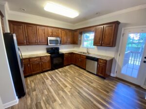 A kitchen with wooden cabinets and floors