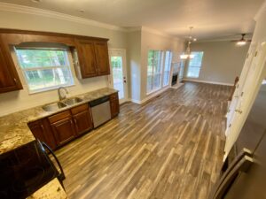 A kitchen with wood floors and wooden cabinets.