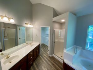 A bathroom with a walk in shower and a tub.