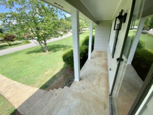 A porch with steps leading to the front door.