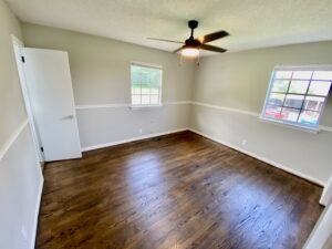 A room with hard wood floors and white walls.