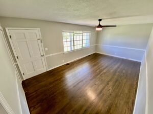 A room with hardwood floors and a ceiling fan.