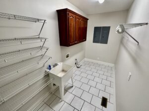 A bathroom with white tile and tiled floors.