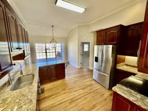 A kitchen with wooden floors and stainless steel appliances.