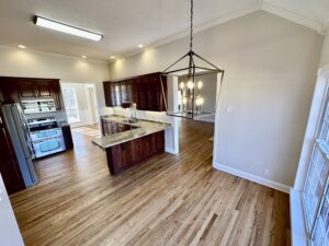 A kitchen with wood floors and white walls.