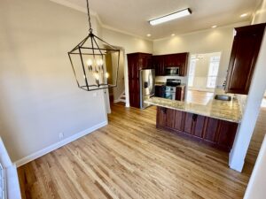 A kitchen with wood floors and white walls.