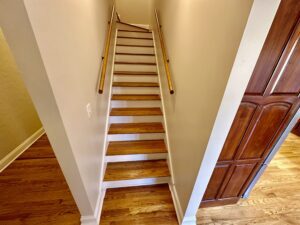 A wooden staircase with wood handrails and steps.