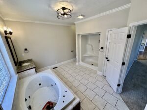 A bathroom with a tub, toilet and shower.