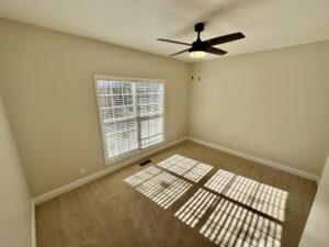 A room with a ceiling fan and a window.