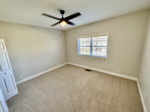 A room with a ceiling fan and a window.