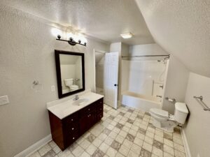 A bathroom with a sink, mirror and toilet.