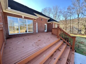 A large deck with steps leading to the back patio.