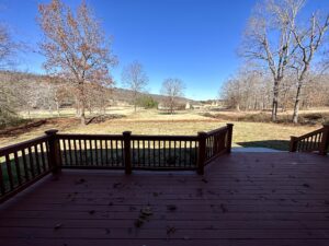 A deck with a view of the woods and trees.