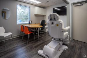 A room with chairs, tables and a television.