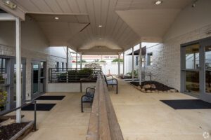 A walkway with benches and chairs in it.