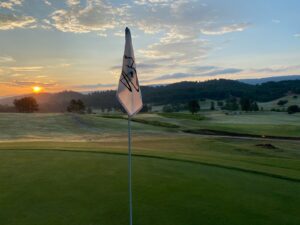 A flag on the edge of a golf course.