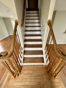 A wooden staircase with white steps and brown treads.