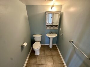 A bathroom with two toilets and a sink.