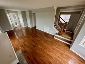 A living room with hard wood floors and stairs.