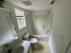 A bathroom with white walls and tile floors.