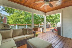 A covered patio with furniture and a ceiling fan.