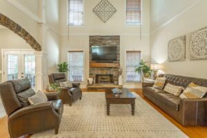 A living room with two large windows and a fireplace.