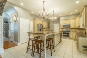 A kitchen with white tile floors and wooden cabinets.