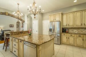 A kitchen with a large island and granite counter tops.