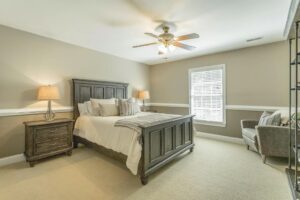 A bedroom with a bed, two nightstands and a window.