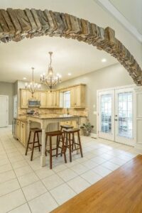 A kitchen with white tile floors and wooden cabinets.