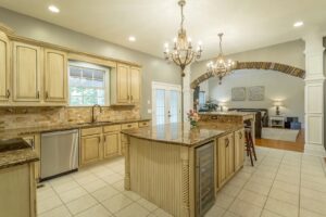 A kitchen with a large island and granite counter tops.