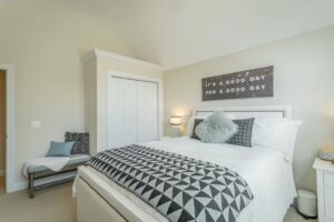 A bedroom with a bed, chair and closet.