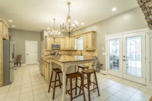 A kitchen with white tile floors and wooden cabinets.