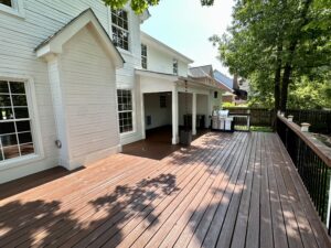 A large deck with a porch and patio furniture.