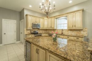 A kitchen with granite counter tops and beige cabinets.