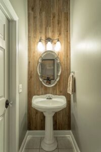 A bathroom with wood paneling and a white sink.