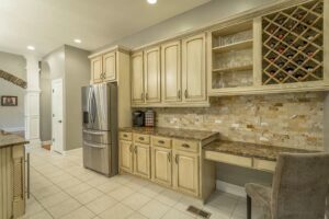 A kitchen of a house with wooden cabinets and a fridge.