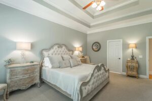 A bedroom with a bed, nightstand and dresser.