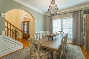 A dining room table with chairs and chandelier.