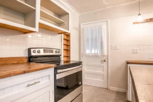 A kitchen with white cabinets and a stove.